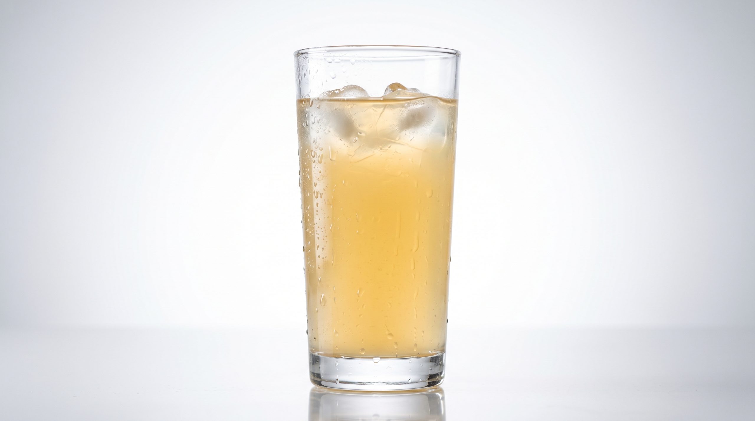 A tall backlit glass of pale citrus functional hydration drink with ice and condensation showing full transparency and no cloudiness, demonstrating clear fiber fortification in sports beverages